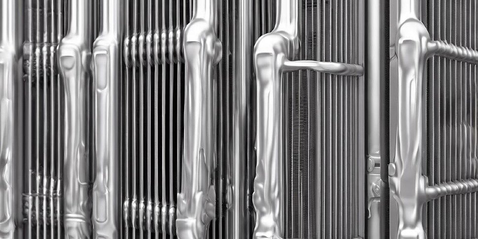 алюминиевые, биметаллические и чугунные радиаторы выстроены в ряд на белом фоне